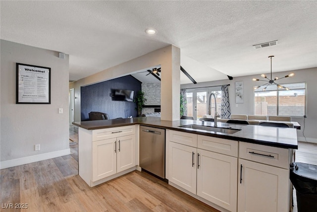 kitchen with white cabinetry, dishwasher, sink, and kitchen peninsula