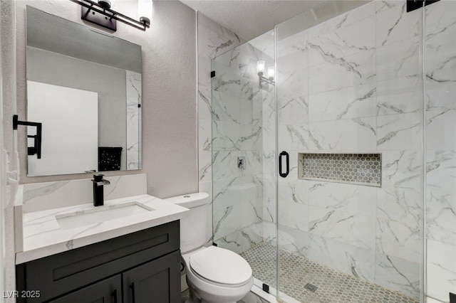 bathroom featuring an enclosed shower, vanity, a textured ceiling, and toilet