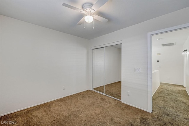 unfurnished bedroom with carpet, ceiling fan, and a closet