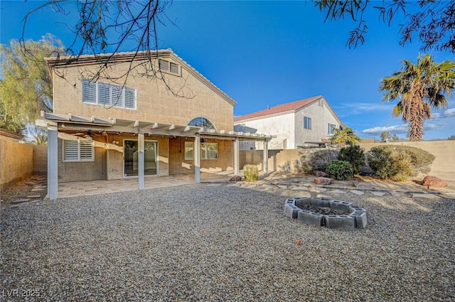 rear view of house with a patio and a fire pit