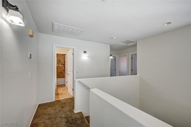 hallway featuring dark colored carpet