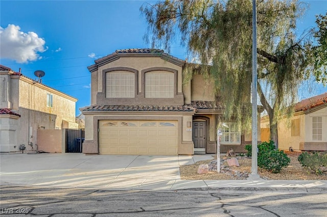 mediterranean / spanish house featuring concrete driveway, an attached garage, a tile roof, and stucco siding