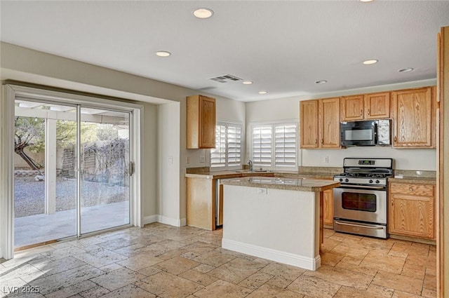 kitchen featuring gas stove, a kitchen island, and sink