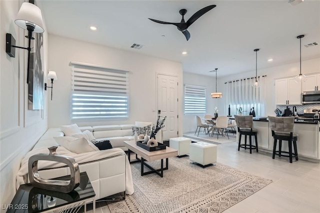 living area featuring a ceiling fan, recessed lighting, and visible vents