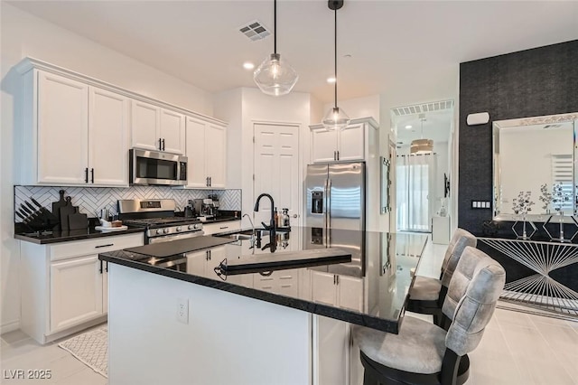 kitchen with pendant lighting, sink, white cabinetry, and appliances with stainless steel finishes