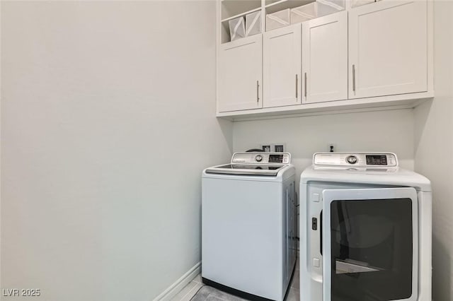 clothes washing area featuring washer and clothes dryer and cabinets