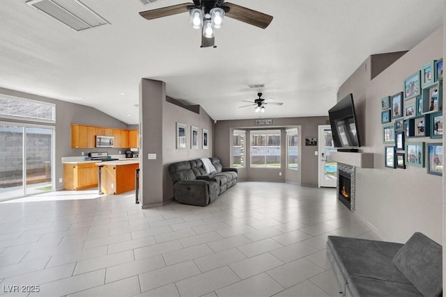 living room with lofted ceiling, light tile patterned floors, and ceiling fan