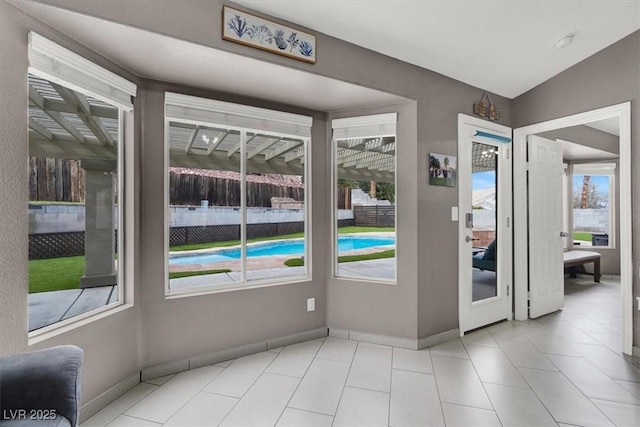 entryway with light tile patterned floors and vaulted ceiling