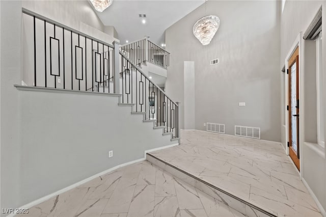 foyer entrance featuring an inviting chandelier and a towering ceiling