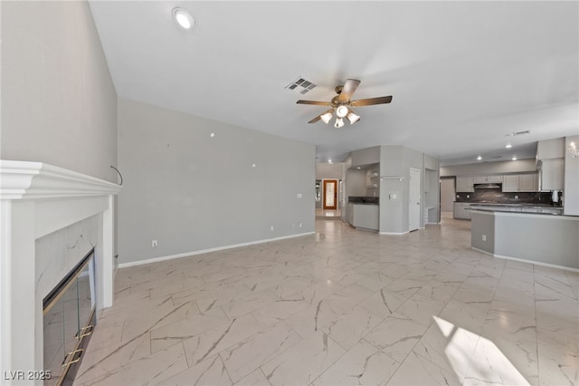 unfurnished living room with a premium fireplace and ceiling fan