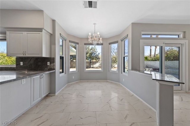 unfurnished dining area with an inviting chandelier