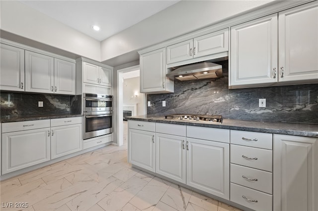 kitchen with stainless steel appliances, tasteful backsplash, and white cabinets