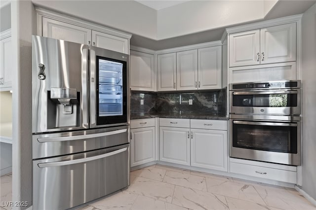 kitchen with backsplash, dark stone counters, and appliances with stainless steel finishes