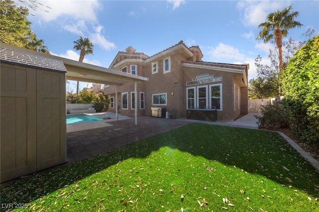 rear view of property featuring a storage shed, a patio area, a fenced in pool, and a lawn