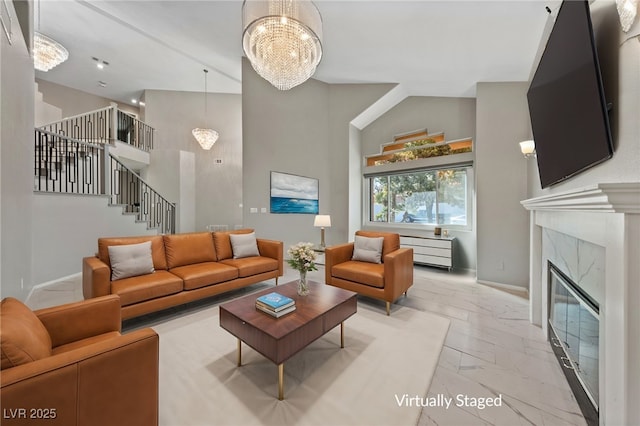 living room featuring a notable chandelier, a high end fireplace, and high vaulted ceiling