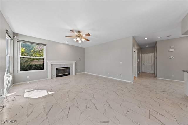 unfurnished living room with ceiling fan and a high end fireplace