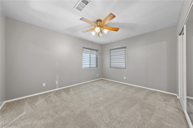 spare room featuring ceiling fan and light carpet