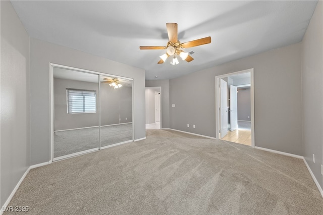 unfurnished bedroom featuring light colored carpet, ceiling fan, and a closet