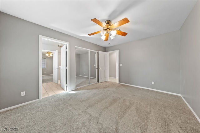 unfurnished bedroom with ensuite bathroom, light carpet, and ceiling fan