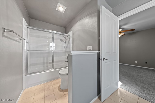 bathroom featuring ceiling fan, tile patterned floors, toilet, and combined bath / shower with glass door