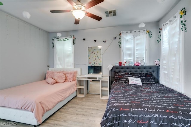 bedroom with visible vents, a ceiling fan, and wood finished floors