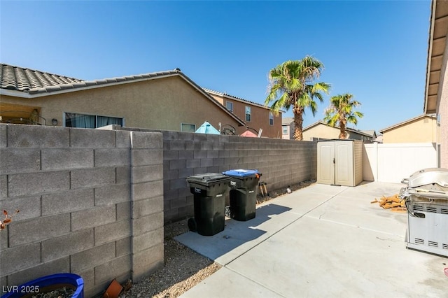 view of patio / terrace featuring a shed, an outdoor structure, and a fenced backyard