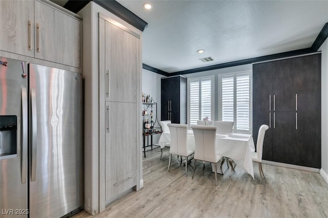 dining space featuring visible vents, recessed lighting, crown molding, and light wood-type flooring