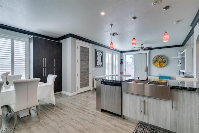 kitchen featuring visible vents, a sink, light wood-style floors, crown molding, and dishwasher