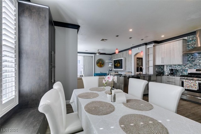 dining area featuring dark wood-style floors, plenty of natural light, visible vents, and arched walkways