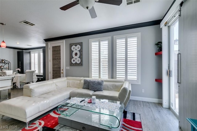 living room with a ceiling fan, baseboards, visible vents, and light wood-type flooring