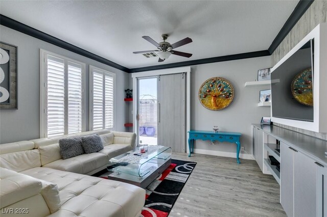 living area with baseboards, a ceiling fan, light wood-style floors, and ornamental molding