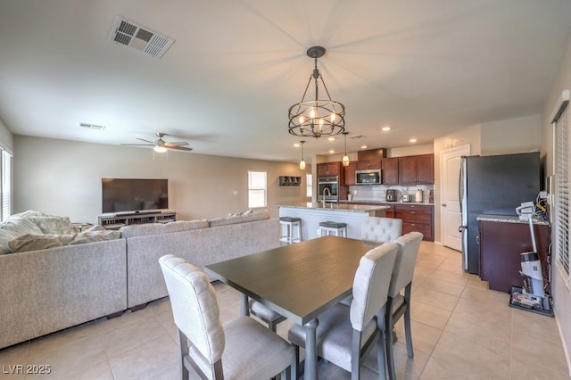 tiled dining room with sink and ceiling fan