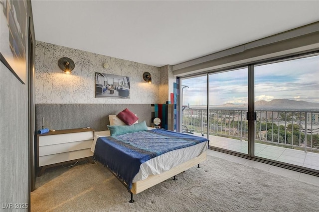 bedroom featuring access to exterior, a mountain view, and carpet floors