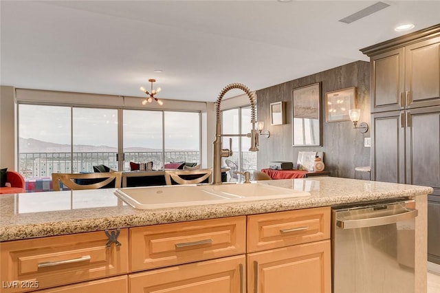 kitchen featuring sink, a mountain view, stainless steel dishwasher, and wood walls