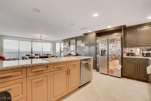 kitchen featuring light tile patterned flooring, sink, stainless steel dishwasher, light stone counters, and fridge with ice dispenser