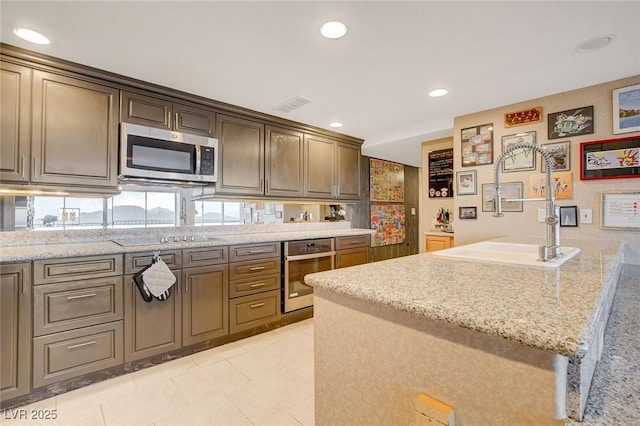 kitchen featuring light stone counters, light tile patterned floors, and appliances with stainless steel finishes