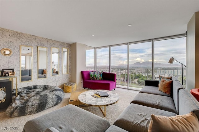 carpeted living room featuring expansive windows and a mountain view