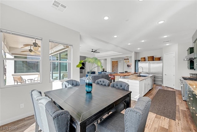 dining area with sink, ceiling fan, and light hardwood / wood-style flooring