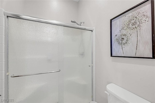 bathroom with an enclosed shower and toilet