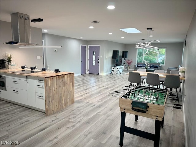 interior space featuring recessed lighting, baseboards, visible vents, and light wood finished floors