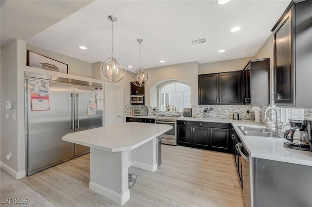 kitchen featuring visible vents, appliances with stainless steel finishes, light countertops, and a sink