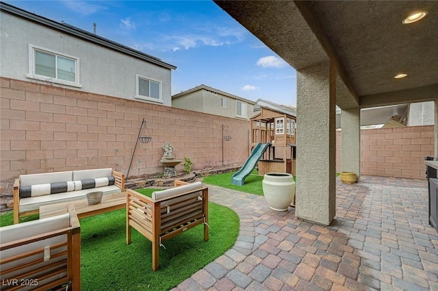 view of patio / terrace featuring outdoor lounge area, a playground, and a fenced backyard