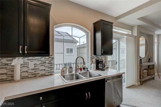 kitchen featuring a sink, tasteful backsplash, carpet floors, light countertops, and dishwasher