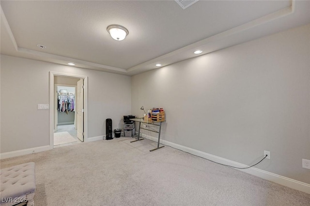 misc room featuring recessed lighting, light colored carpet, a raised ceiling, and baseboards