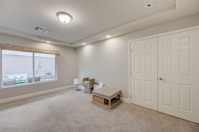 living area featuring carpet, visible vents, baseboards, a tray ceiling, and recessed lighting