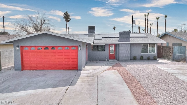 ranch-style home featuring a chimney, stucco siding, a shingled roof, fence, and a garage