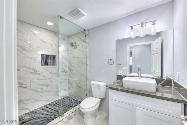 bathroom featuring a marble finish shower, visible vents, toilet, marble finish floor, and vanity