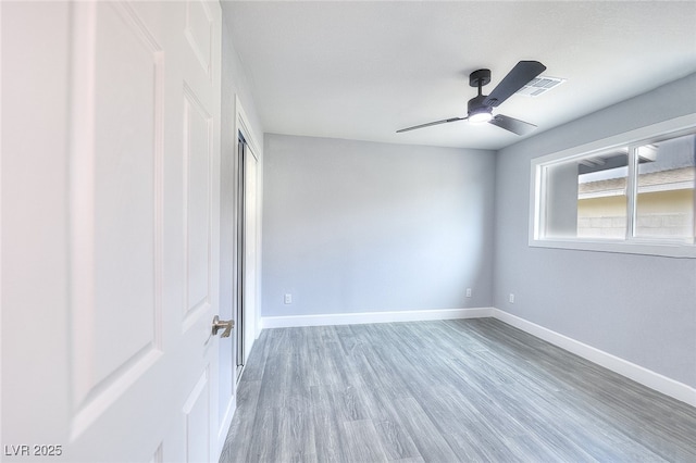 unfurnished bedroom featuring visible vents, baseboards, a ceiling fan, wood finished floors, and a closet