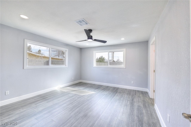 spare room featuring baseboards, visible vents, wood finished floors, and recessed lighting