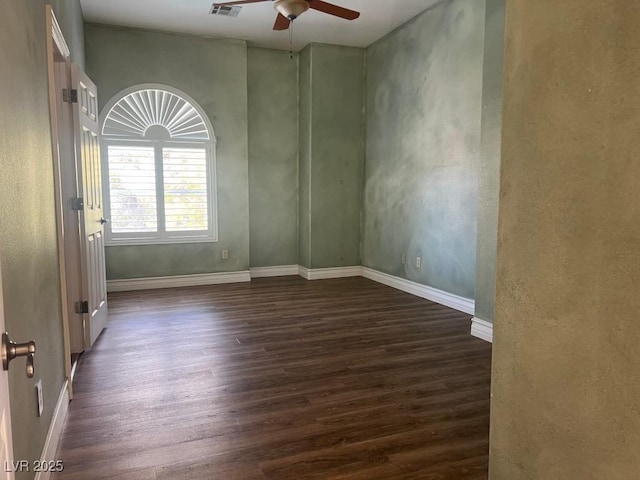 spare room featuring dark wood-type flooring and ceiling fan